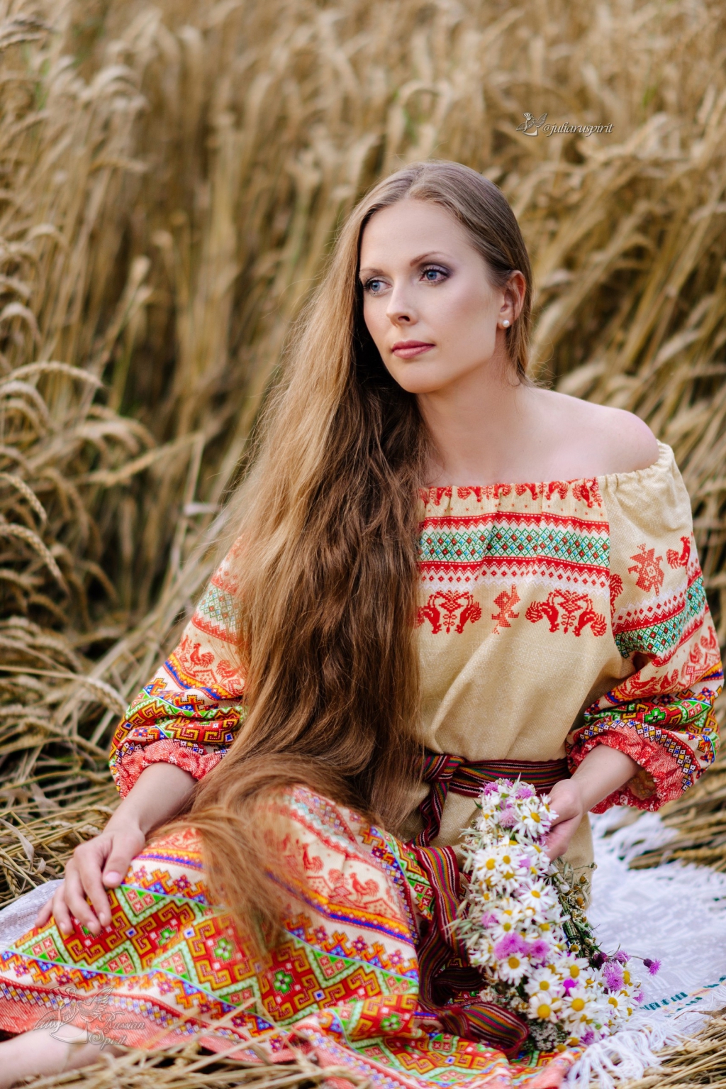 девушка в платье в русском стиле в сидит в пшеничном поле