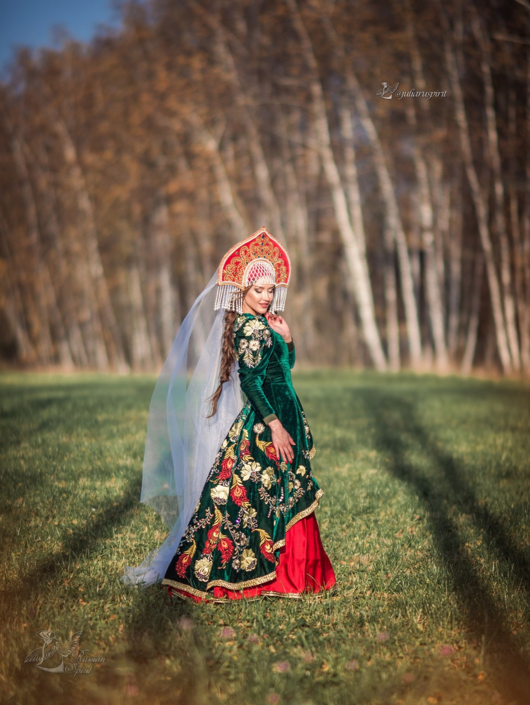 Девушка в вышитом узорами платье в кокошнике на фоне леса