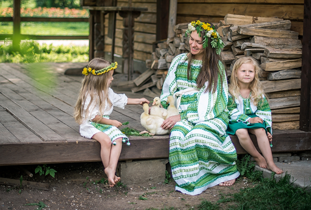 Мама с дочками в русских народных костюмах на крылечке с утятами