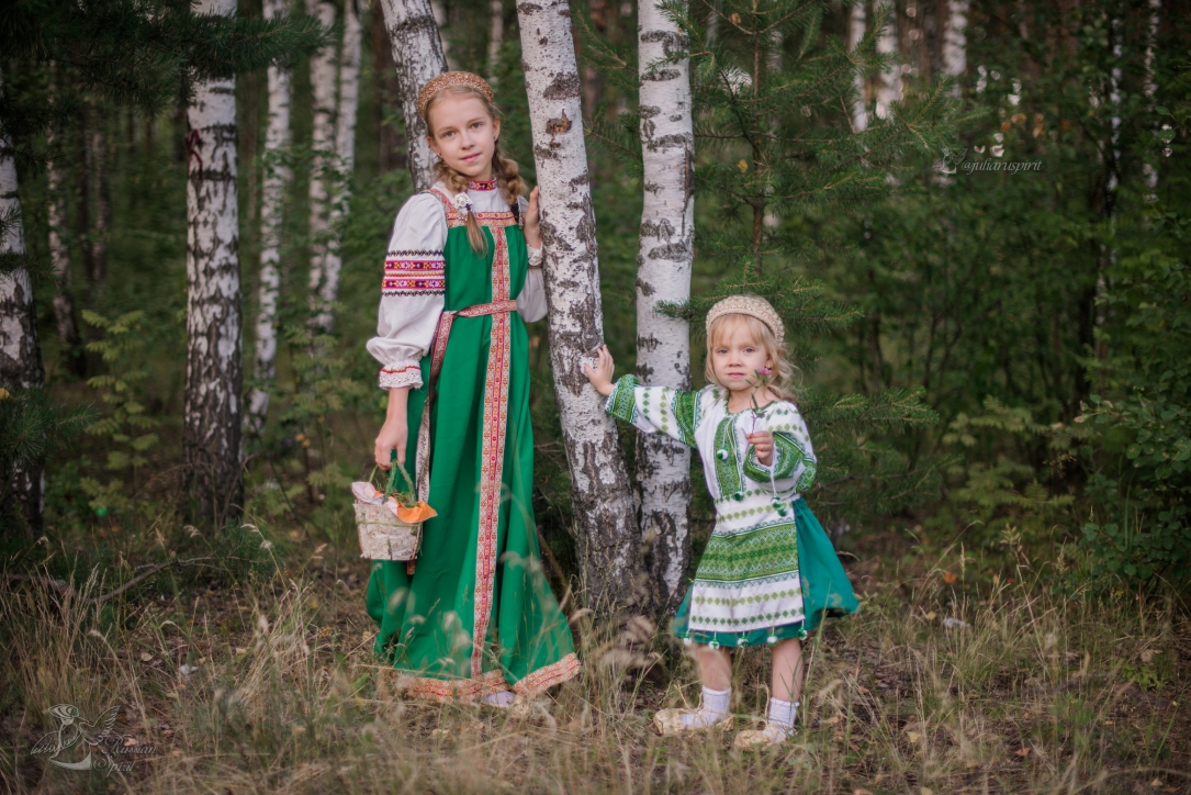 Сестрёнки в русских народных костюмах в лесу у берёзок с корзиной