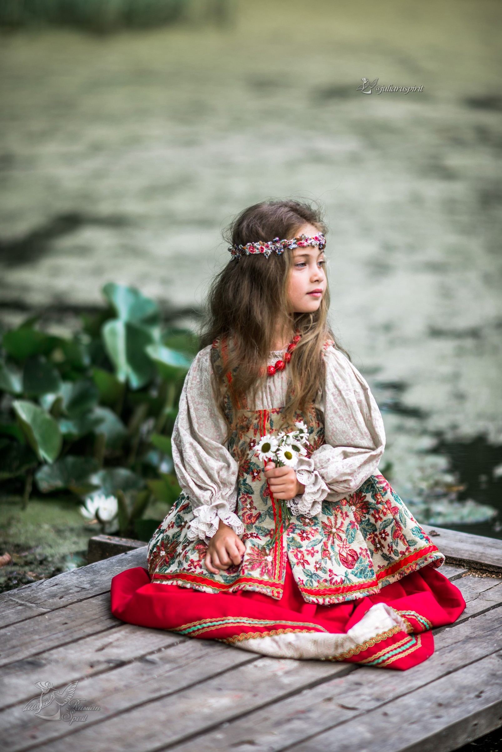 Девочка на мостике у пруда в национальном русском платье