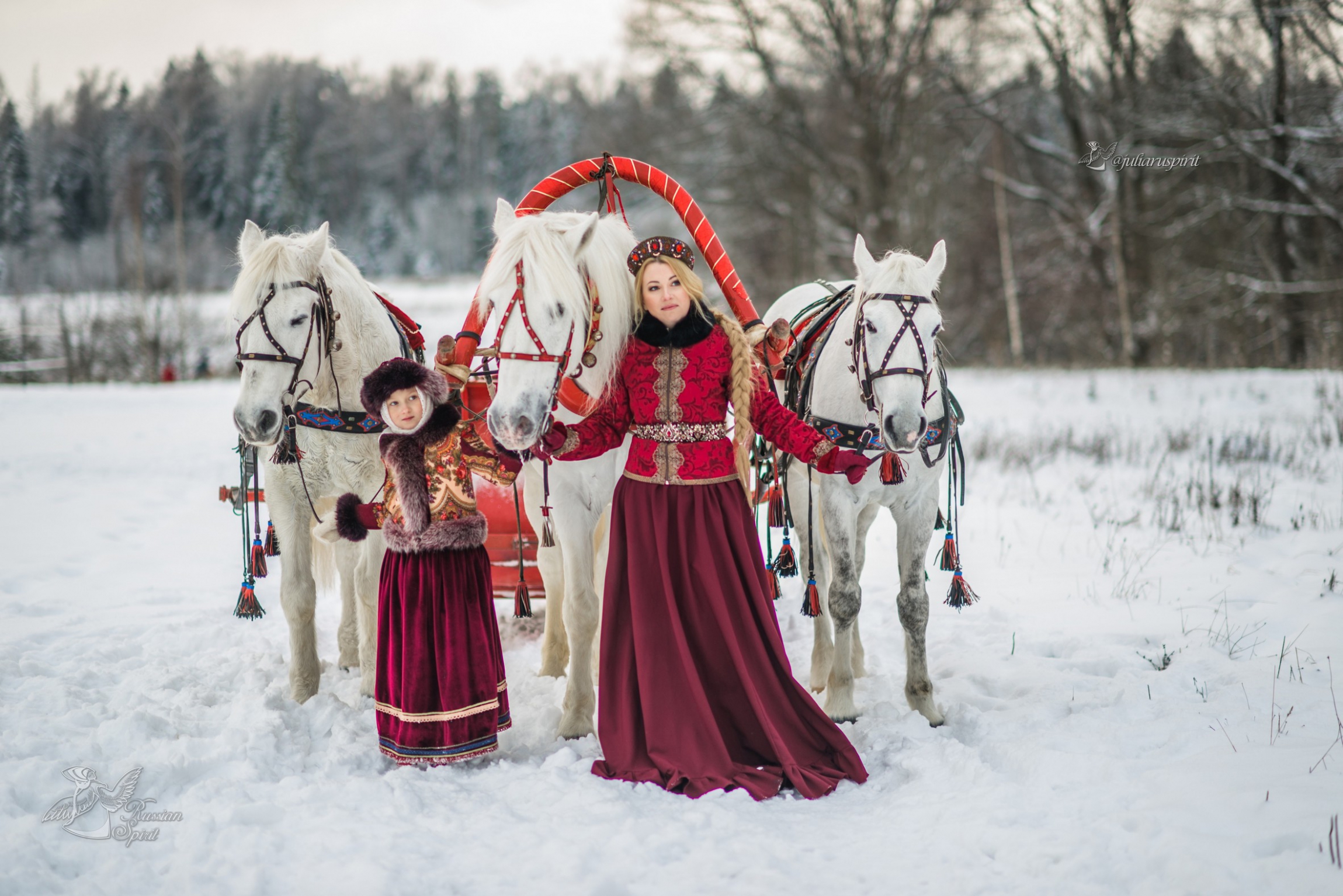 Мама с дочкой в русских народных костюмах с тройкой лошадей