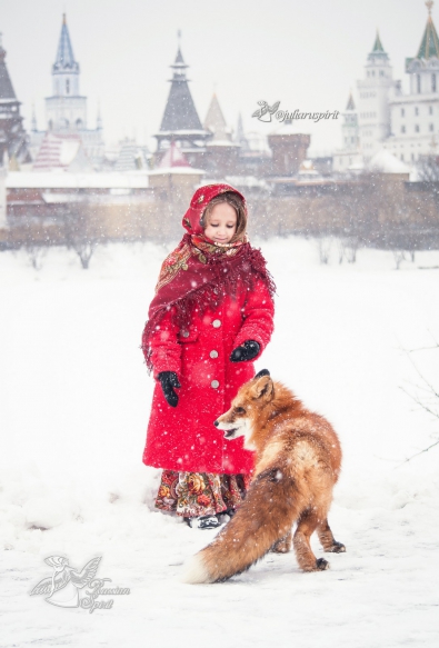 Девочка кормит лису на фоне измайловского кремля