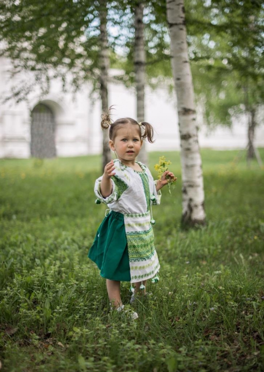 Девочка в березках в русском народном костюме на фоне измайловской усадьбы