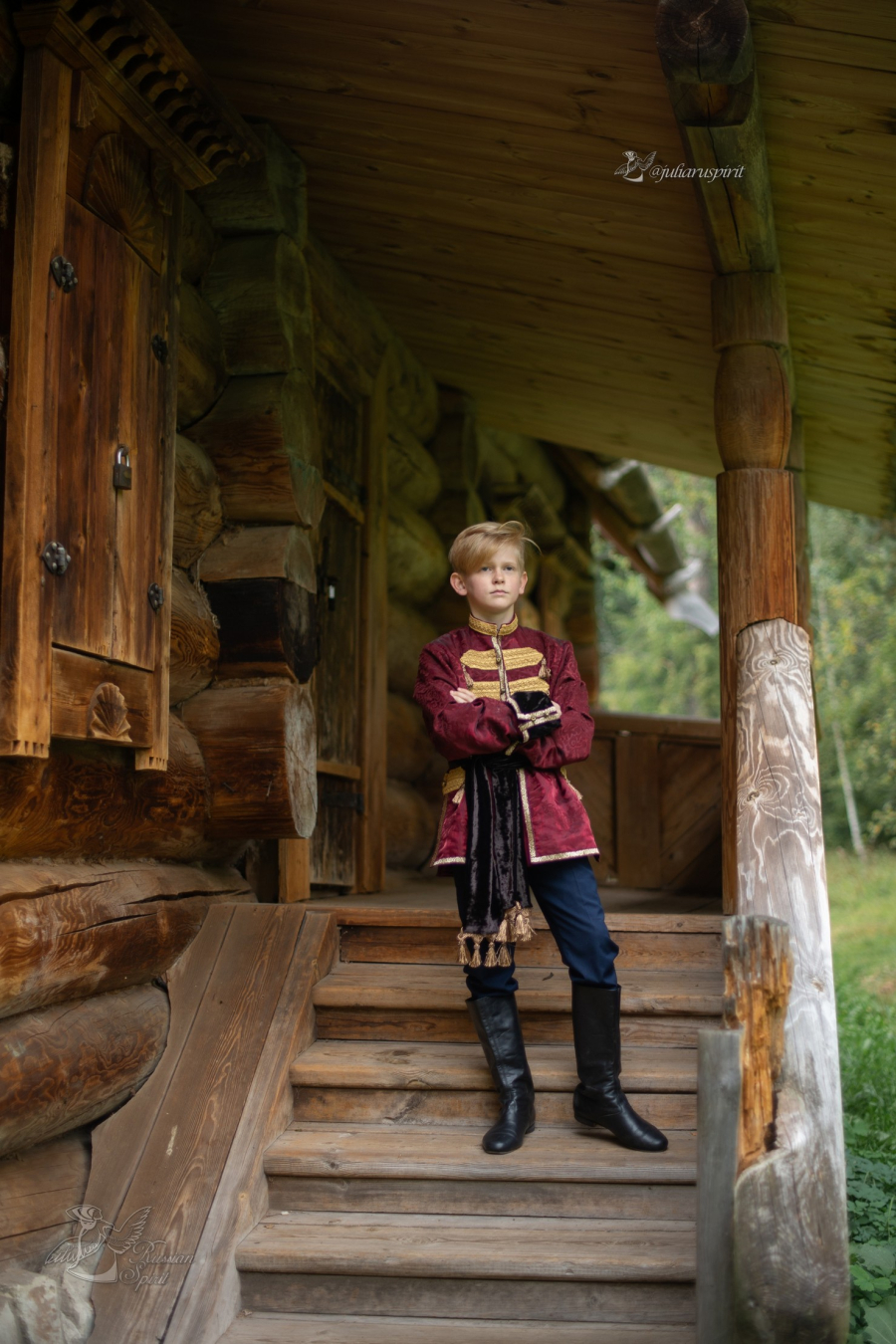 Мальчик в костюме в русском стиле на лестнице деревянного дома